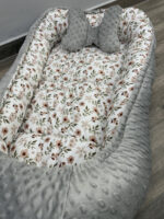 βρεφική φωλιά χρώματος γκρι με λουλουδάκια της άνοιξης στο εσωτερικό